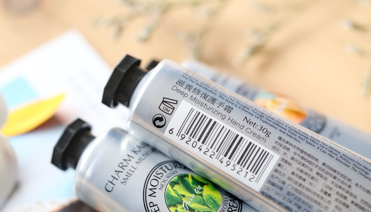 Two hand cream tubes, one showing the printed barcode on its side.