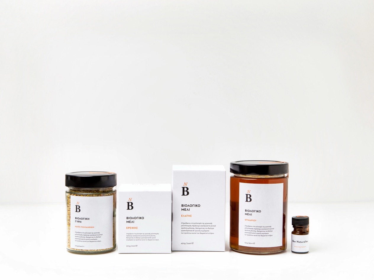 Jars, cartons and a dropper bottle of honey products on a white surface.