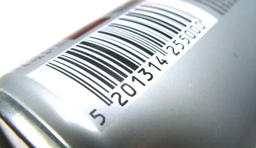 A barcode printed on the shoulder of a metal bottle.